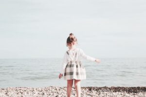 A girl walking towards the beach 