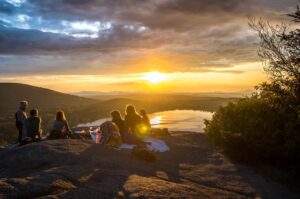 Camping tours in a mountain facing the sunset.