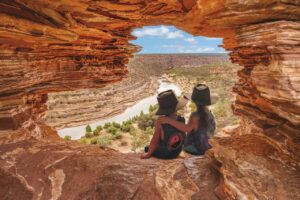 Two kids sitting in a cave 