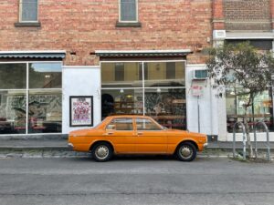 Orange car Infront of a Restaurant