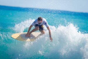 white shirt man surfing in the beach