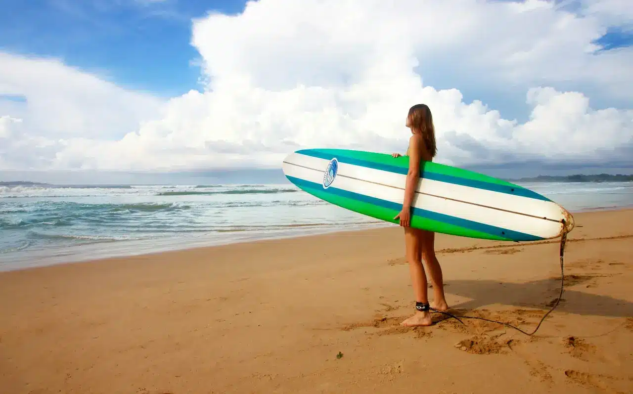 Woman Holding a Surfboard on the Beach